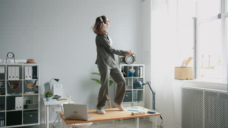 woman dancing on a desk in a home office