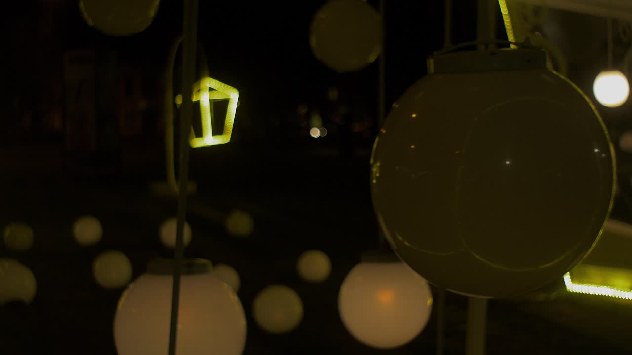adornos navideños al aire libre por la noche, farolillos artísticos y grandes bolas de luz parpadeantes, plano medio