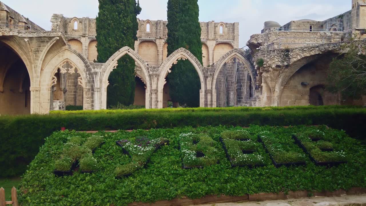 Bellapais Village and Kybele Abbey with big green ornamental bushes. Medieval building facade. Slow motion. Kyrenia, Cyprus