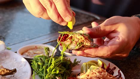 hands preparing oysters with herbs and sauces