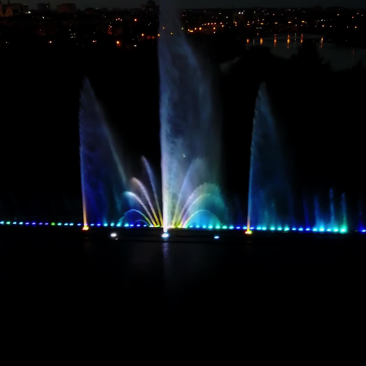 Beautiful Dancing Fountain. Aerial shot of the colorful illuminated musical fountain at dusk