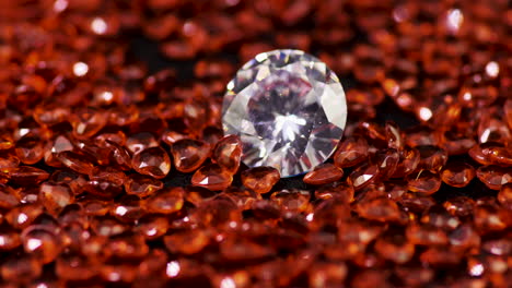 real brilliant-cut shining diamond surrounded by the heart-shaped rubies on the turntable rotating clockwise close-up - highly valuable and expensive gemstones for fashion and weddings