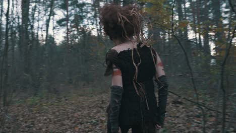 back view of a forest woman walking through trail of trees in wilderness