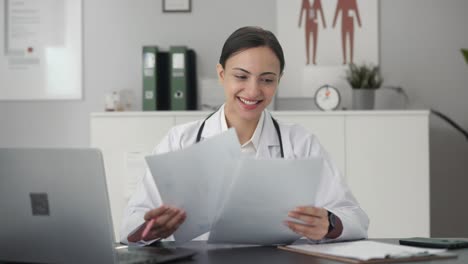 Happy-Indian-female-doctor-checking-medical-reports