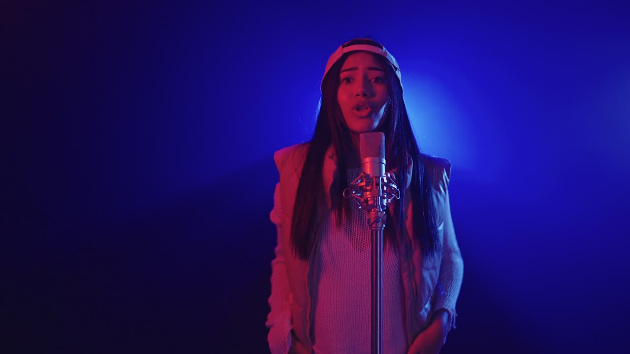 Woman singing into microphone in studio