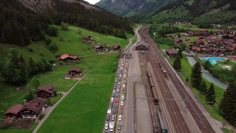 vista aérea de automóviles y trenes haciendo cola para la entrada del túnel de montaña túnel lötschberg en suiza