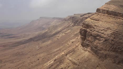 Time-Lapse-clouds-in-arid-desert,-mountains-at-the-background,-Israel,-static-shot