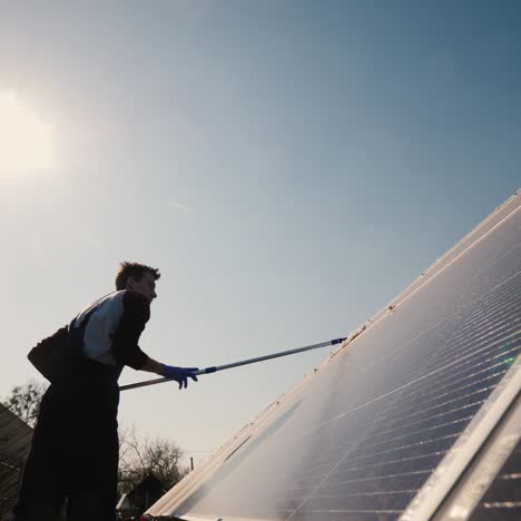 silhouette of a man who wipes dust on solar panels