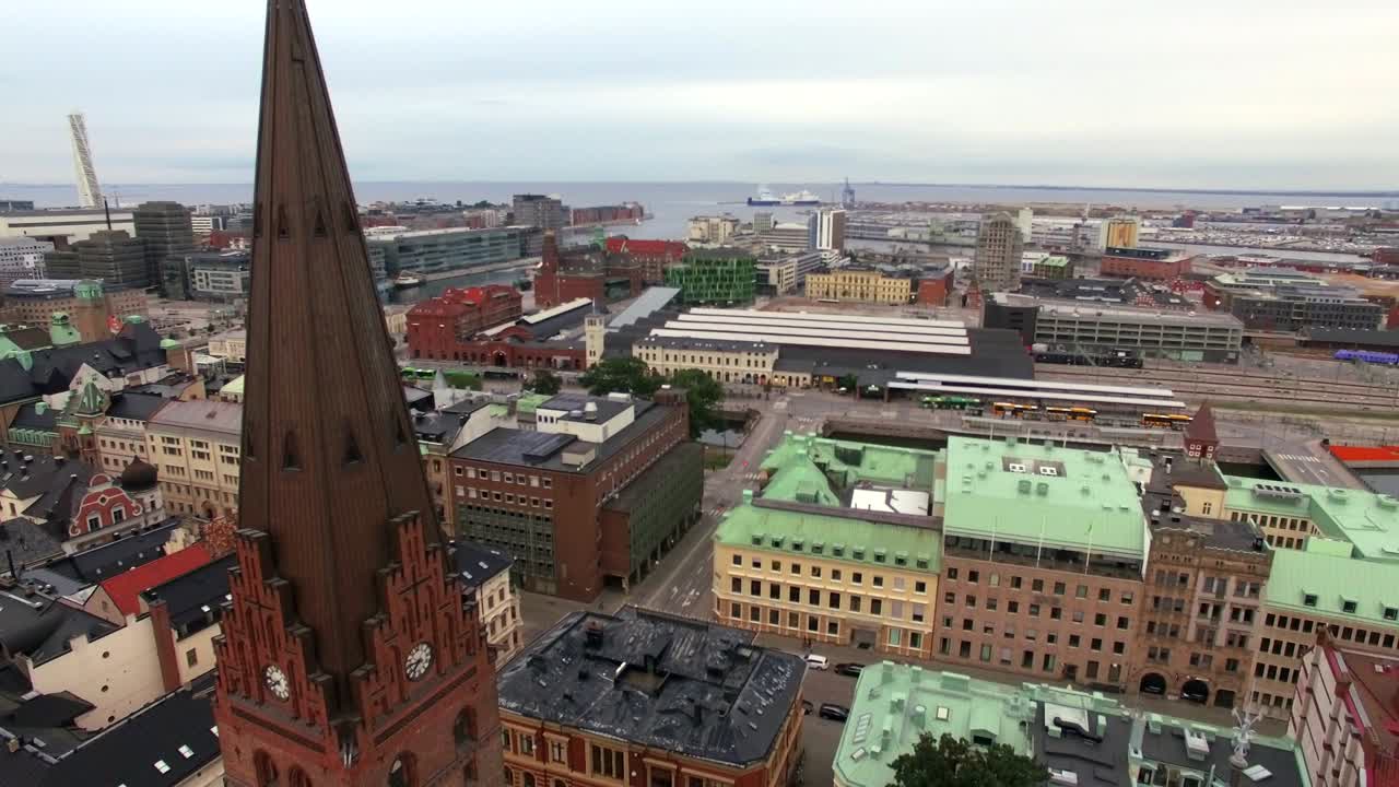 fotografía aérea volando hacia abajo frente a la iglesia en la ciudad de malmö. vista de drones de edificios del paisaje urbano en el fondo