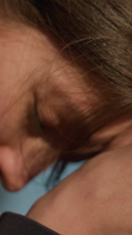 toma de primer plano de las manos frotándose suavemente, gesto de profunda contemplación y dolor. la cabeza es parcialmente visible, sugiriendo un momento de tristeza y reflexión contra un fondo de cielo despejado
