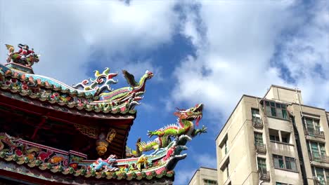 pan across downtown apartment buildings to traditional longshan temple in taipei taiwan on sunny day