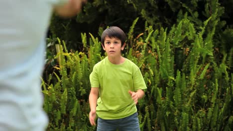 father throwing a football for his young son to catch