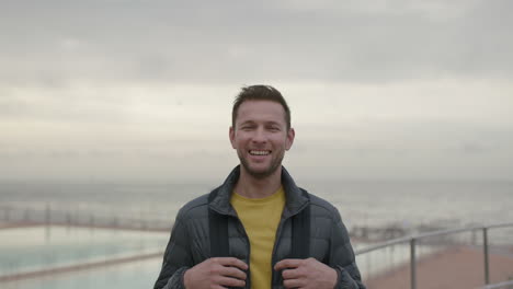 Primer-Plano-Retrato-De-Un-Hombre-Guapo-Riendo-Alegre-En-La-Playa-Nublada