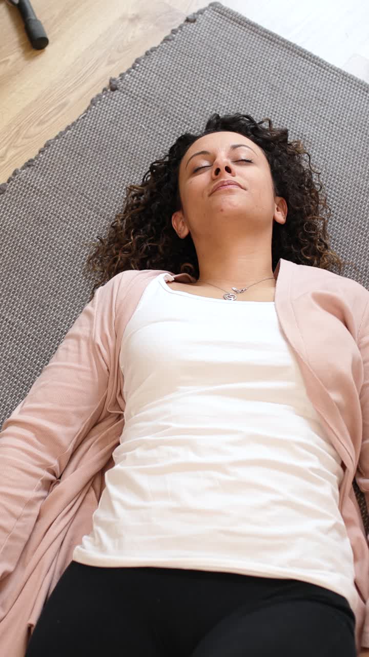 Woman relaxing on carpet, changing positions