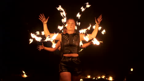 Tres-Mujeres-Con-Aros-Encendidos-Bailan-Con-Antorchas-Ardientes-Vestidas-De-Cuero-En-Un-Hangar-Oscuro-Demostrando-Un-Espectáculo-De-Fuego-De-Circo-En-Cámara-Lenta