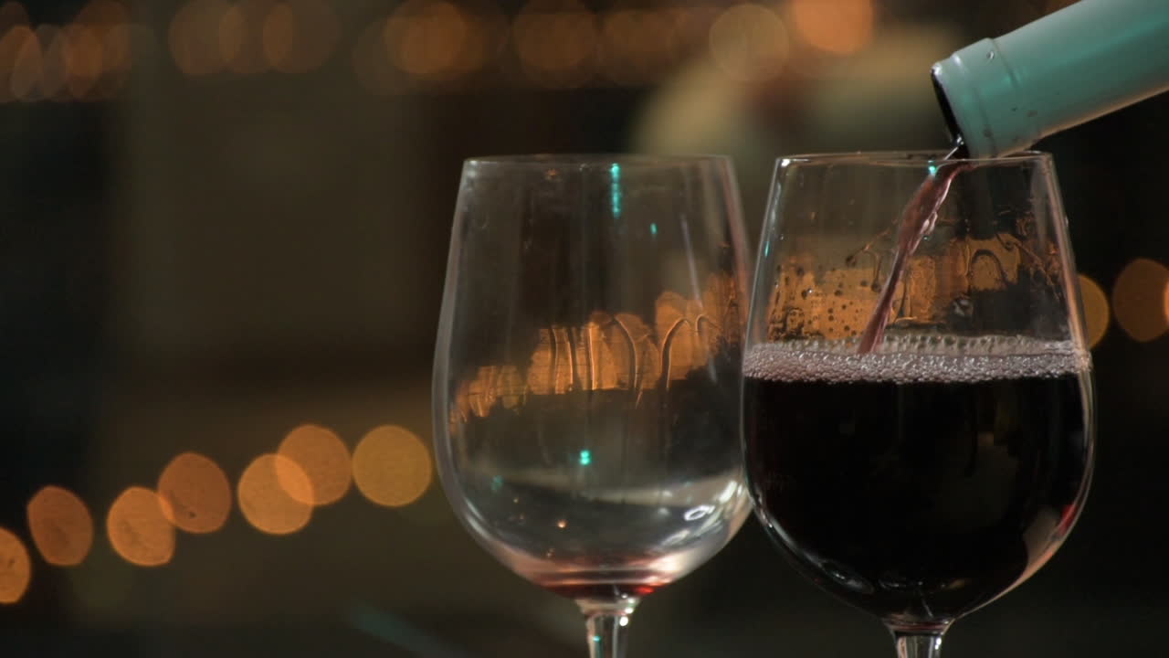 Close Up of Pouring Red Wine in Two Wineglasses. Romantic Valentine Date Concept
