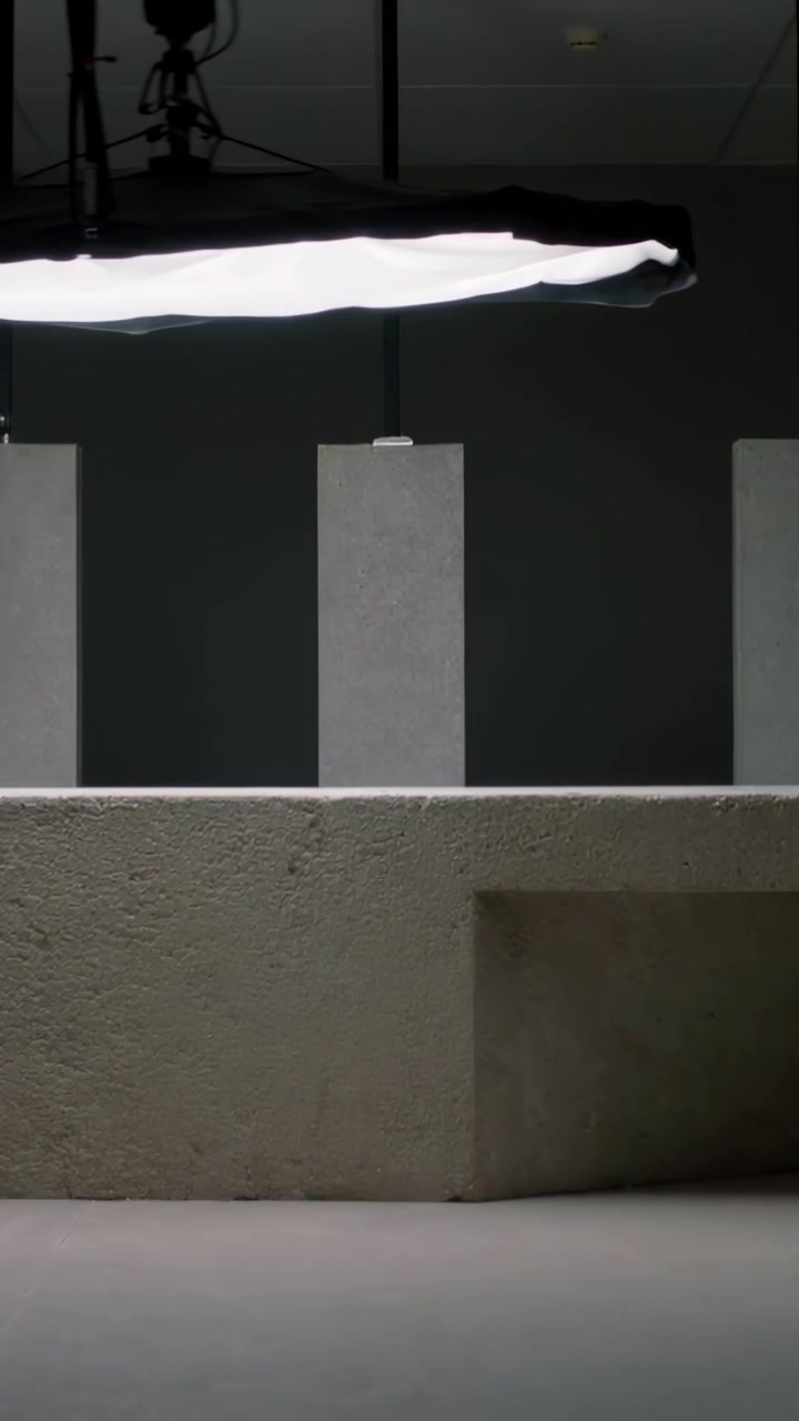 Video verticale: Spostamento di un softbox motorizzato attraverso il soffitto dello studio, regolazione della luce sopra una panca di cemento.