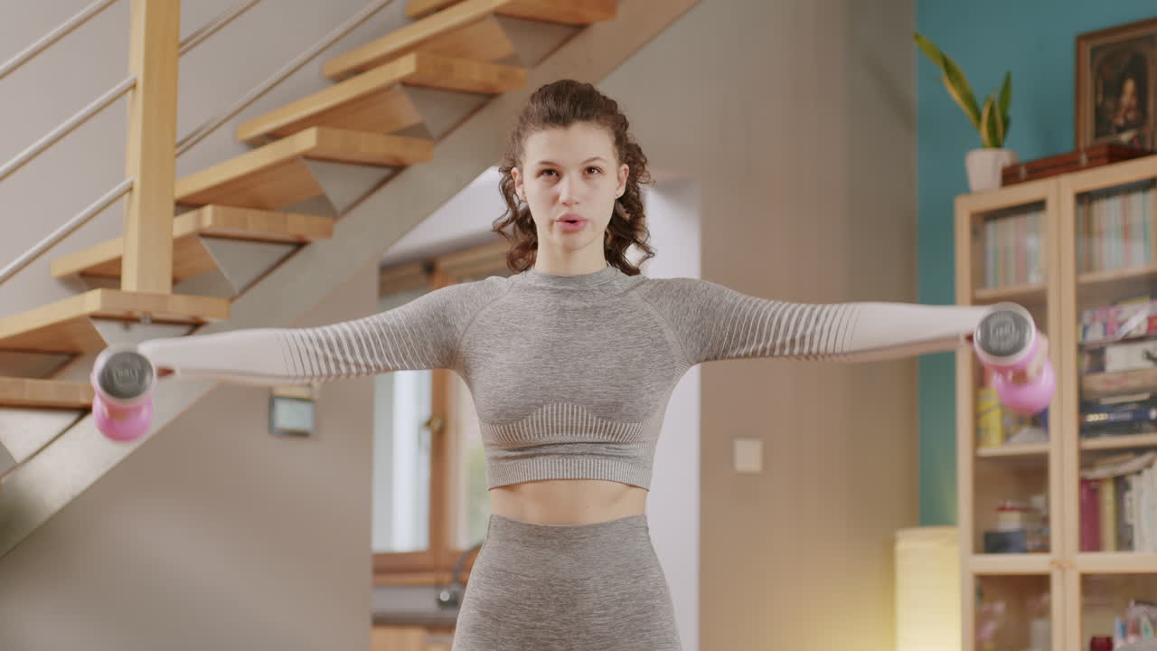 홈 피트니스 운동에 무게와 운동 젊은 갈색 머리 여자 훈련 어깨