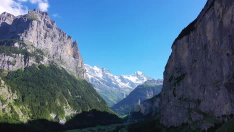 Towering-Mountain-Walls-and-steep-rock-Face-cliffs-surrounding-Alpine-Swiss-Valley-Village-of-Lauterbrunnen,-Switzerland