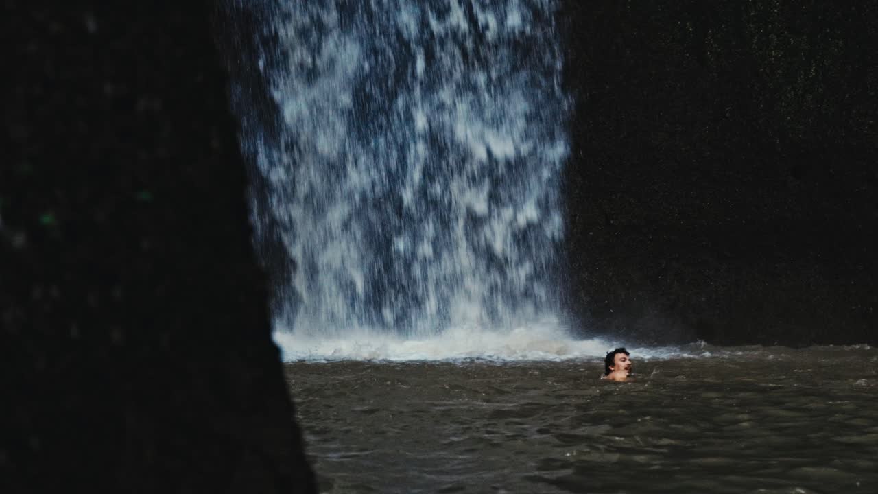 인도네시아 발리에서 느린 움직임으로 높은 폭포와 물에서 수영하는 사람