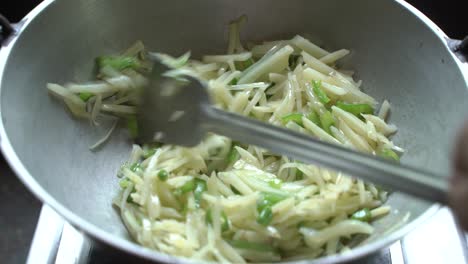 a woman prepares pasta at home with silverware