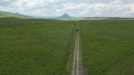 Car-Path-in-the-Middle-of-a-Valley-with-Green-Field-of-Grass-as-Far-as-the-Eye-Can-See