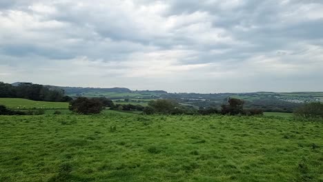 scenic welsh green countryside farmland meadows and coastal bay rural scene panning right