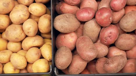 Rote-Und-Rostrote-Kartoffeln-In-Behältern-Auf-Dem-Markt-Zum-Verkauf---Overhead-Isoliert-Nahaufnahme-Schiebeansicht