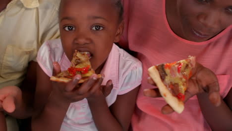 Happy-family-eating-pizza-on-couch