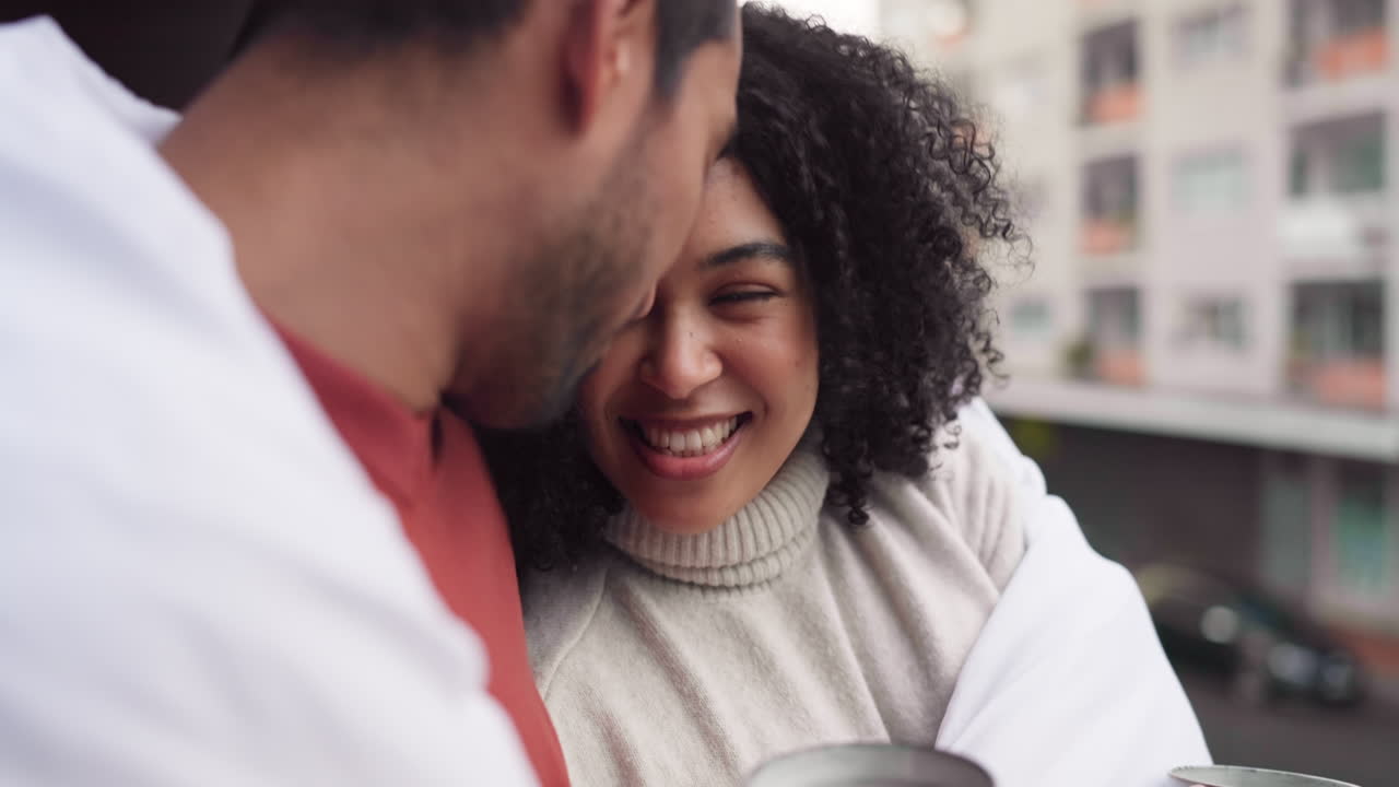Couple laughing on a balcony