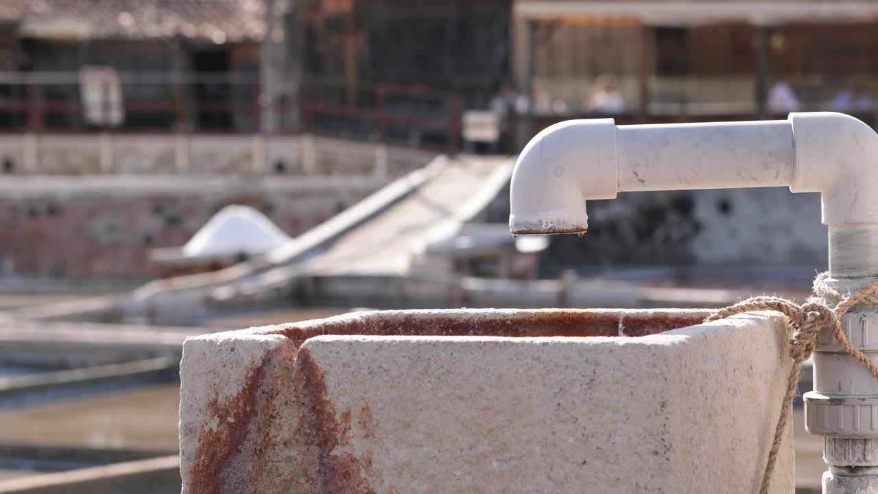 Vand drypper fra åbne rør på en saltfarm i Rio Maior, Portugal