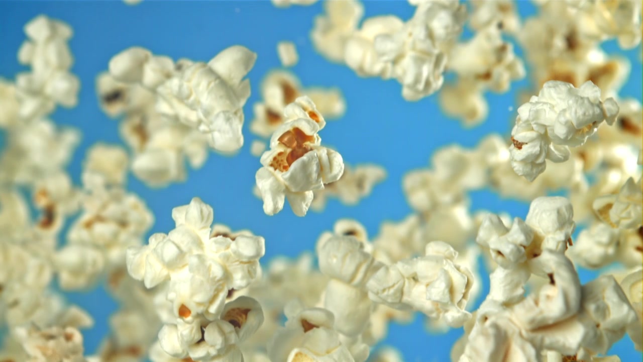 Popcorn fresco in volo al rallentatore su sfondo blu
