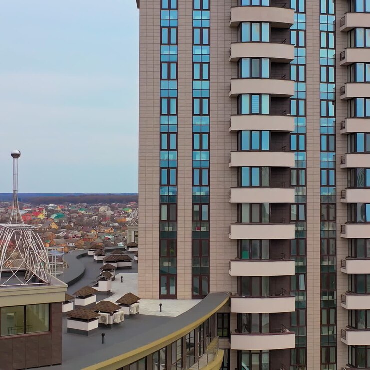 Edificio multipiano dal design innovativo per una struttura elevata in città. Vista aerea di bellissimi appartamenti di edilizia residenziale pubblica a molti piani. La telecamera si sposta a destra.