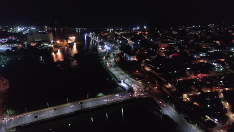 floating bridge at night, santo domingo in dominican republic. aerial forward