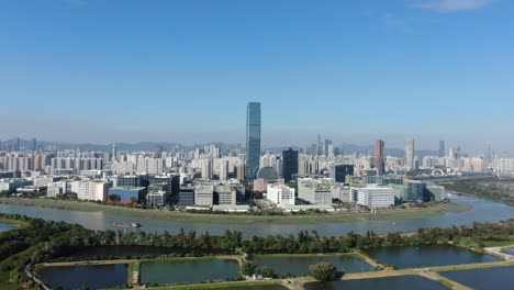 hong kong and shenzhen border line over hong kong rural houses with shenhzen skyline in the horizon, aerial view