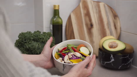 manos femeninas cocinando ensalada vegetariana fresca y mostrando la ensaladera con verduras coloridas dieta para perder peso y comida cruda saludable