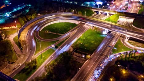 Vista-Aérea-Nocturna-De-Timelapse-De-Una-Intersección-De-Autopistas-Con-Senderos-De-Tráfico-En-Moscú-Nocturna