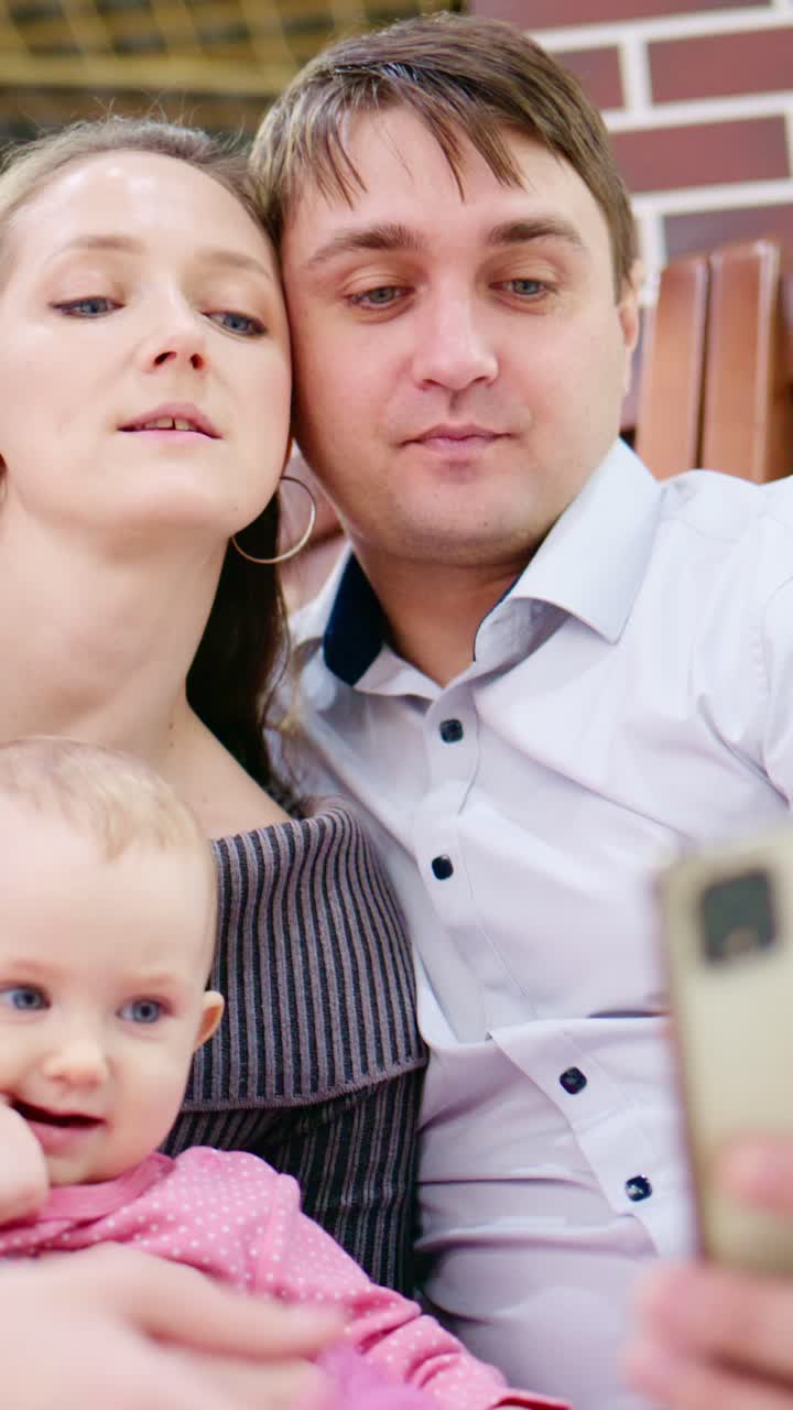 Un tenero momento in famiglia: una coppia affettuosa e il loro adorabile bambino condividono espressioni di gioia e affetto in un ambiente interno accogliente