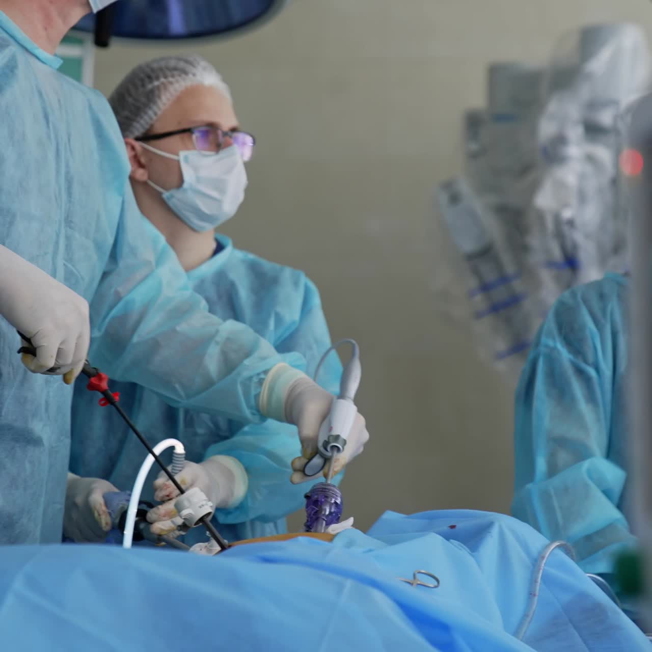 Surgery operation in action with usage of innovative medical equipment. Team of medical professionals working in the surgery. Male and female doctors helping patient