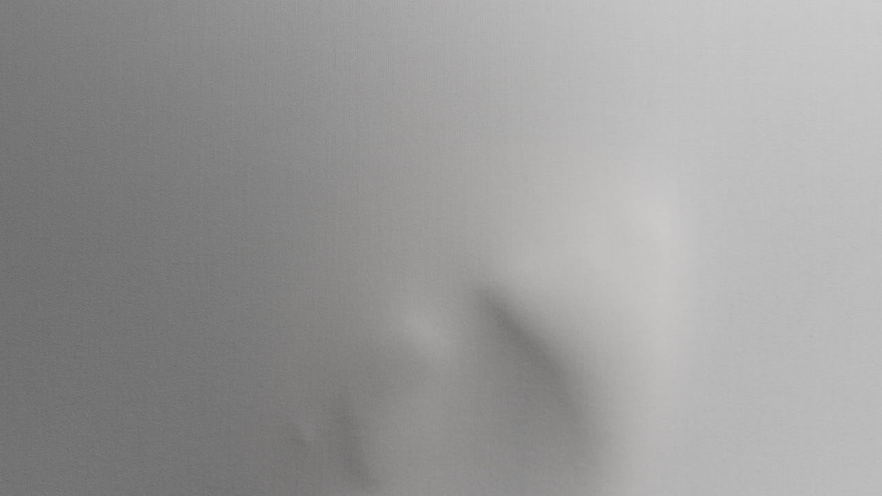 A creepy silhouette of a woman's body appears from the white surface
