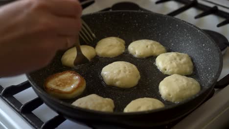 cooking pancakes in home kitchen, dough, hot pan and stove