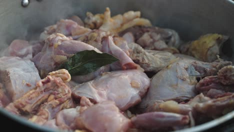 pollo crudo con condimentos listo para cocinar en una olla grande