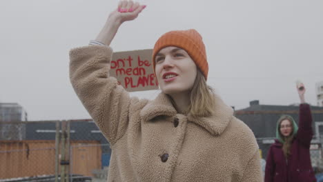 young female activist leading a protest against climate change