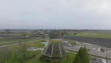 Hermosa-Vista-Aérea-Del-Antiguo-Molino-De-Viento-De-Madera-En-Medio-Del-Campo,-Molino-De-Viento-Prenclavu,-Día-De-Invierno-Nublado,-Amplio-Tiro-De-Drones-Moviéndose-Hacia-Atrás