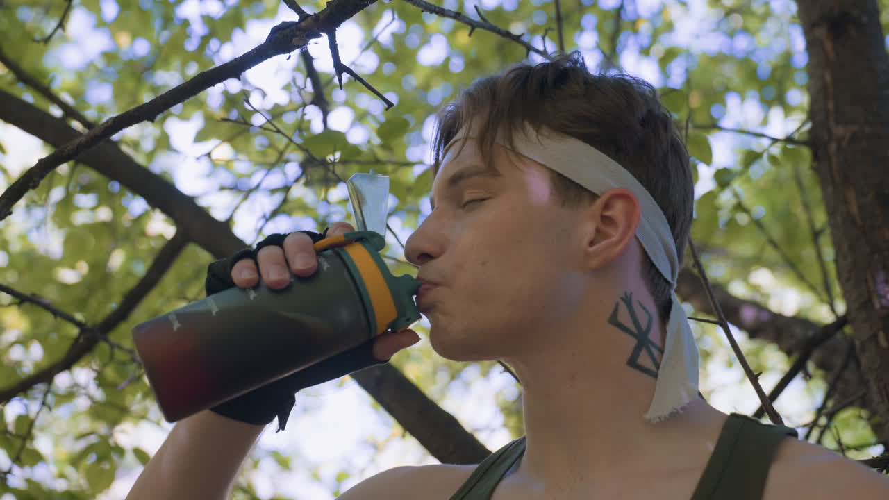 adventurer taking deep drink from water bottle under leafy canopy, exhaling in relief while pausing before journey ahead amid dappled sunlight and forest surroundings, finding serene pause