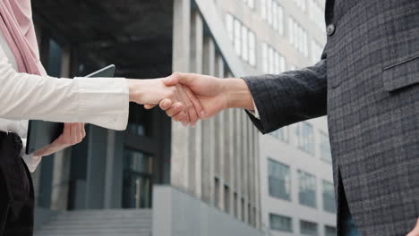 business handshake outside modern building