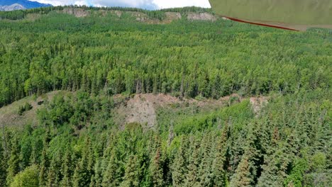 Taking-off-from-a-remote-private-dirt-strip-airport-in-the-Matanuska-Valley-of-Alaska,-near-Palmer,-view-from-the-wing-of-the-airplane