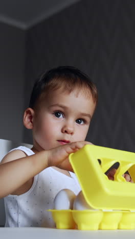 toddler playing with eggs