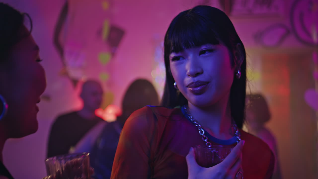 Happy millennial dancing disco club holding alcohol drink in party closeup