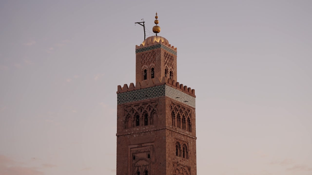 The Koutoubia Mosque minaret glows softly at sunset in Marrakech Medina